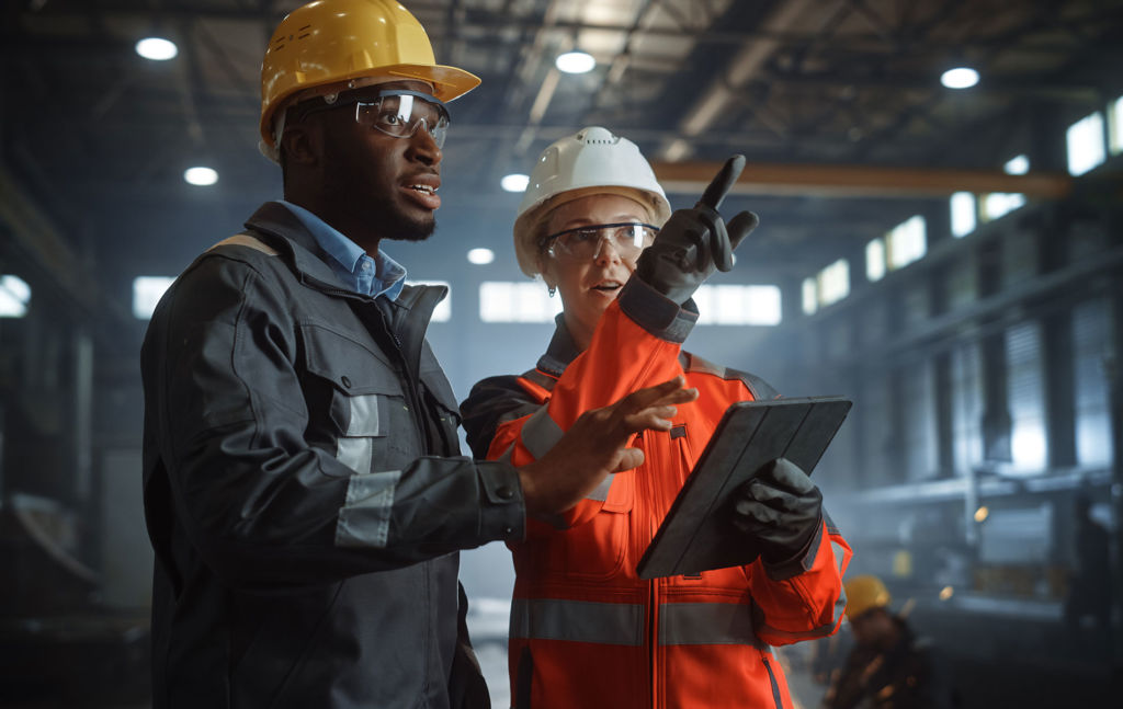 Two people with a tablet discussing construction activities